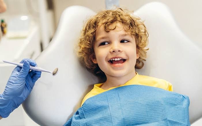 Dentist performing a gentle initial dental exam for a child in Patna