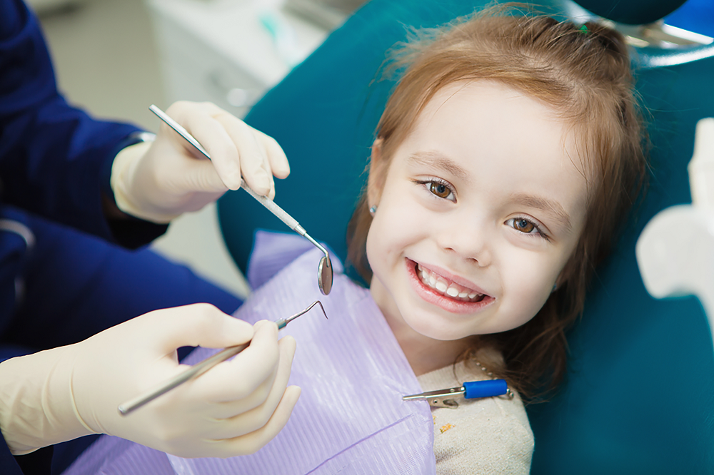 Dentist checking a child's healing progress during a pediatric follow-up visit in Patna