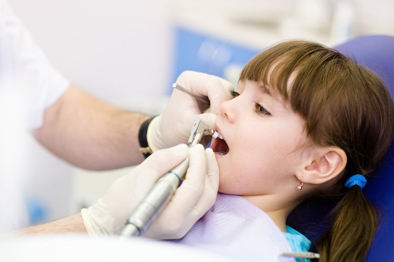 Pediatric dentist performing pulp therapy on a child's baby tooth in Patna